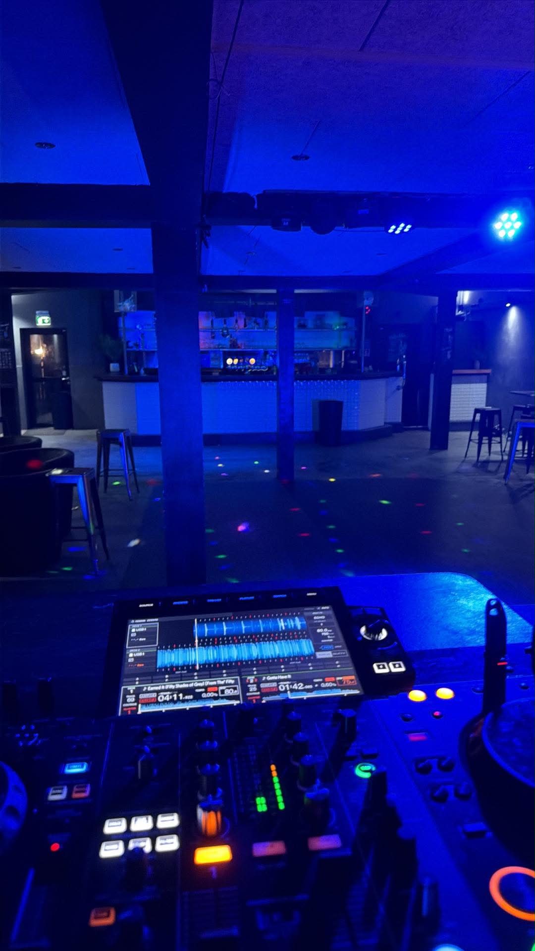 DJ-pult i klubben klar med lys og laser før festen